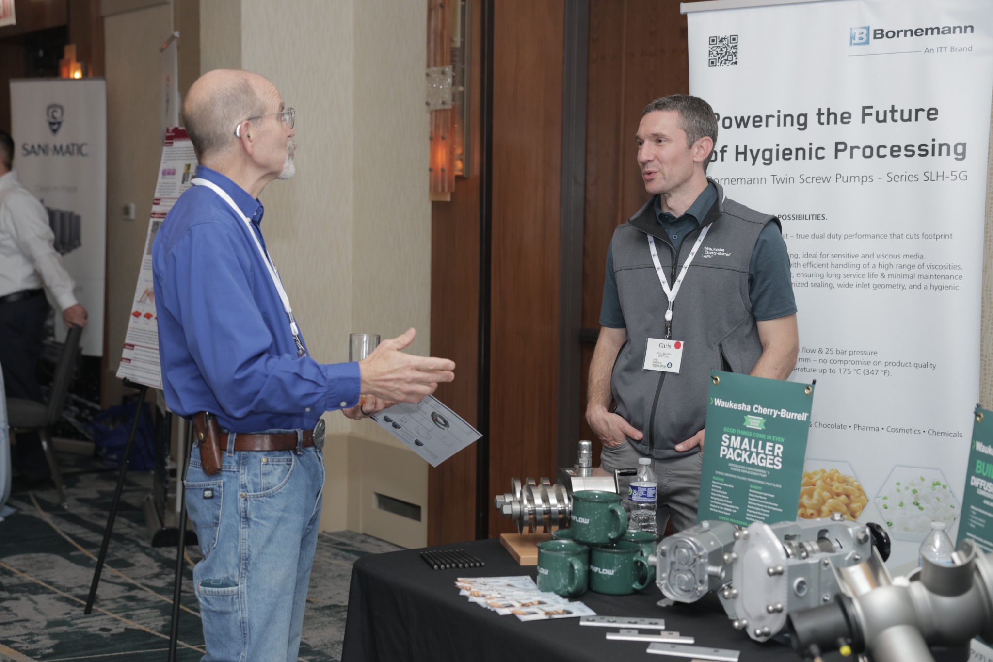 People talking at an equipment booth